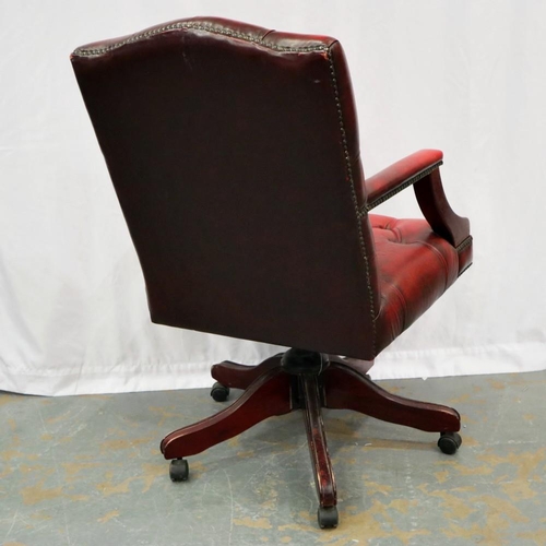 2127 - A 20th century Chesterfield style swivel desk chair, upholstered in ox blood leather on a five spoke... 