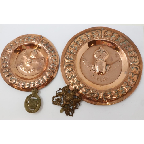 2228 - Two WWI copper relief trays for Royal Navy Air Service, with a WWI cap badge and War Service buttonh... 