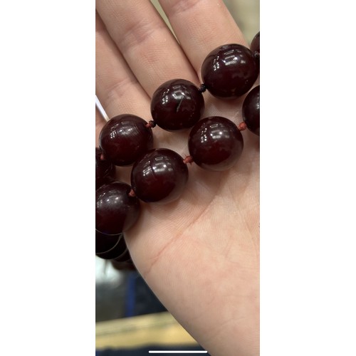 77 - Cherry amber bead necklace with individual knots to string, L: 102 cm, weight: 153.68g, the habbes a... 