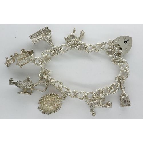 47 - Hallmarked silver charm bracelet with seven charms, padlock clasp and safety chain, L: 18 cm, 47g. U... 