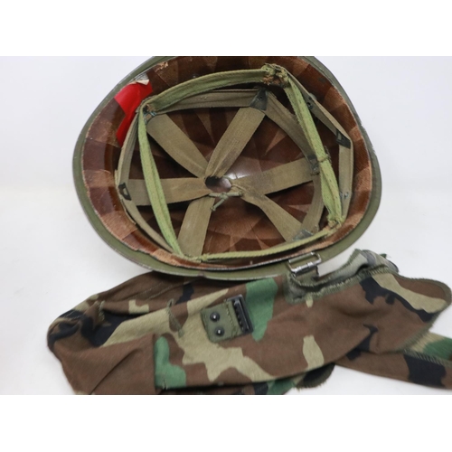 2113 - An American M-1 helmet and liner, with later memorial painting, with and camouflage cover. UK P&P Gr... 