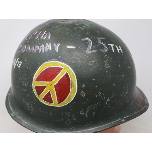 2131 - An American M-1 helmet and liner, later painted with Vietnam War US Airborne memorial, with camoufla... 