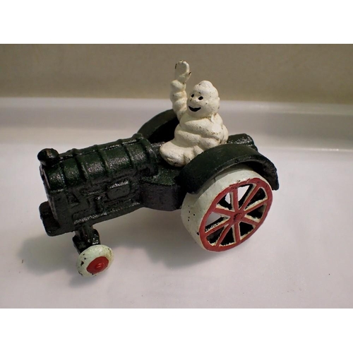 1163 - Cast iron Michelin man on tractor. H: 80mm UK P&P Group 1 (£16+VAT for the first lot and £2+VAT for ... 