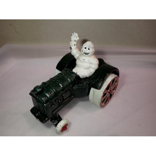 1064 - Cast iron Michelin man on a tractor, H: 80 mm. P&P Group 1 (£16+VAT for the first lot and £2+VAT for... 