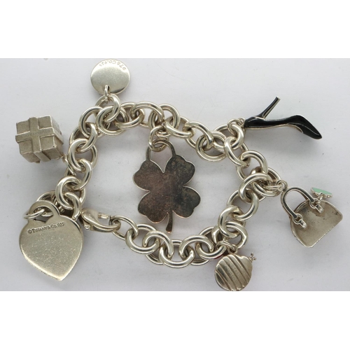 53 - 925 silver charm bracelet marked for Tiffany & Co with seven charms, receipt of £141 for the enamell... 