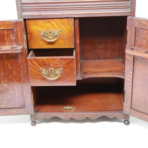 361 - Carved oak smokers cabinet with pipe racks and two drawers, lacking one finial, H: 45 cm. Not availa... 