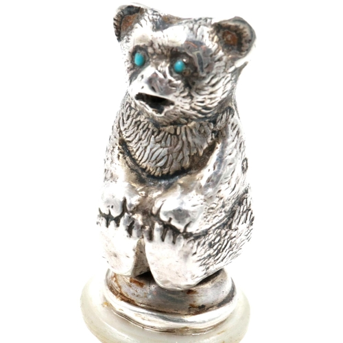 137 - Edwardian hallmarked silver teddy bear figurine, set with turquoise eyes and mounted on a turned woo... 