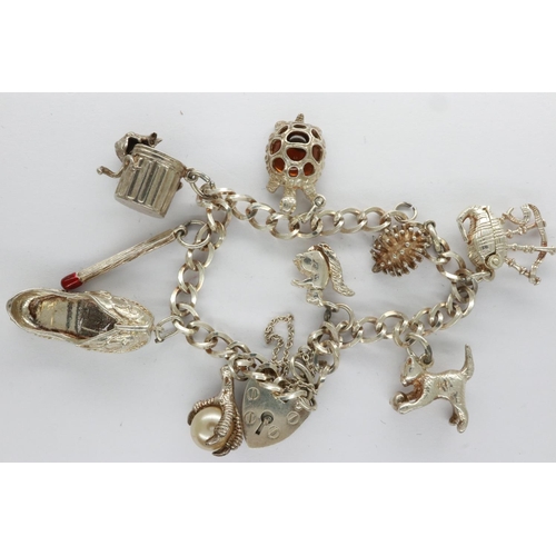 32 - Silver charm bracelet with padlock clasp and nine charms, L: 18 cm. UK P&P Group 0 (£6+VAT for the f... 