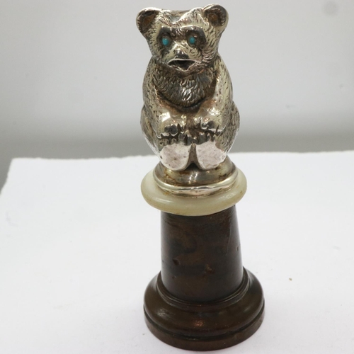 137 - Edwardian hallmarked silver teddy bear figurine, set with turquoise eyes and mounted on a turned woo... 