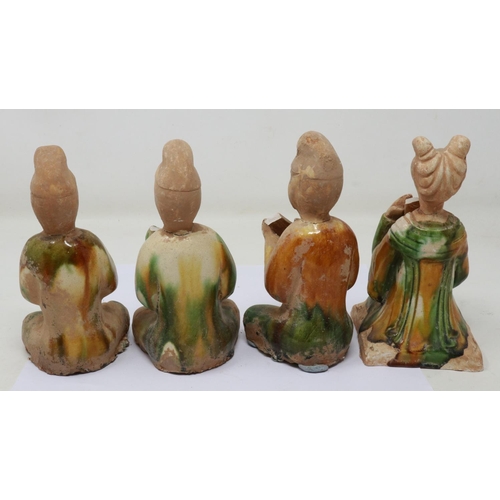 165 - Four Ming Dynasty glazed tomb guardians, each holding musical instruments, losses and repaired damag... 