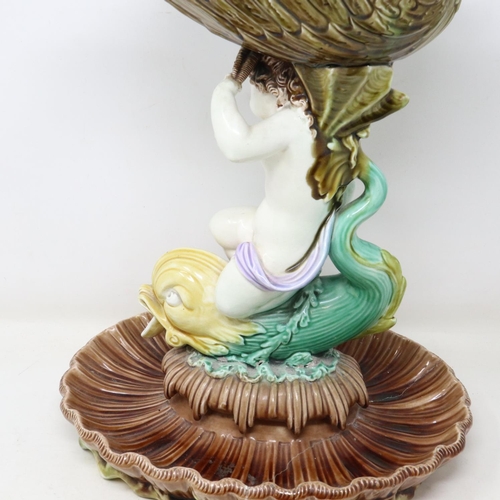 167 - 19th century majolica comport formed as a putti supporting a shell bowl on a stylised fish, staple r... 