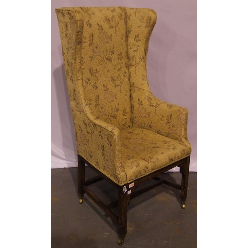 2084 - A 19th century fireside armchair, with winged high back and oak sub frame, raised on brass castors, ... 