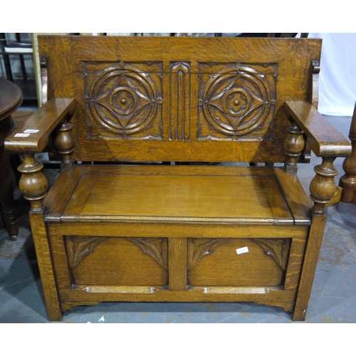 2086 - An early 20th century oak monks bench, the hinged top with carved decoration and the box-seat panell... 