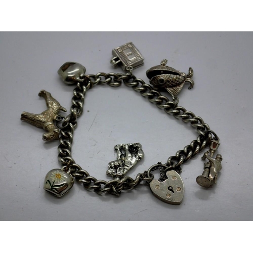 68 - Hallmarked silver charm bracelet with seven charms, padlock clasp and safety chain, L: 18 cm. UK P&P... 