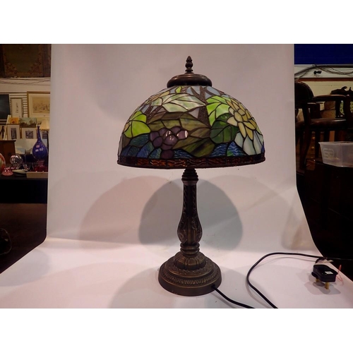 370 - Tiffany style table lamp on a brass base, shade decorated with flowers, H: 58 cm. All electrical ite... 