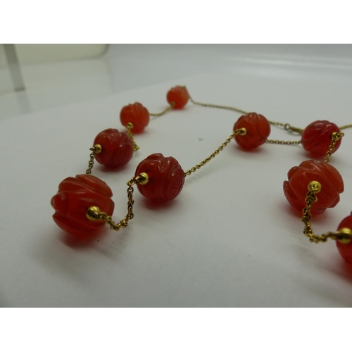 75 - Unusual 19th century unmarked gold necklace, set with eleven carved carnelian beads, L: 63 cm. UK P&... 