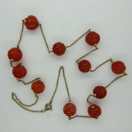 82 - Unusual 19th century unmarked gold necklace, set with eleven carved carnelian beads, L: 63 cm. UK P&... 