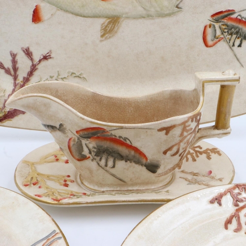 227 - Nine relief moulded fish plates, one platter and one sauce bowl with stand, crazing and some cracks,... 