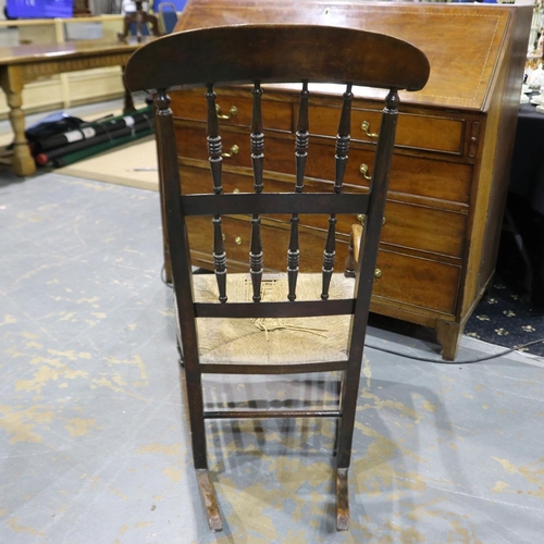 2073 - A 19th century country elm rocker, with rushed seat and turned spindle back. Not available for in-ho... 