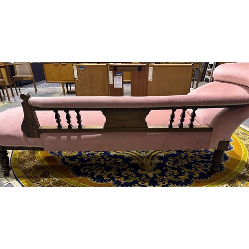 2040 - A Victorian chaise lounge, having a carved and moulded oak frame, turned supports terminating in cas... 