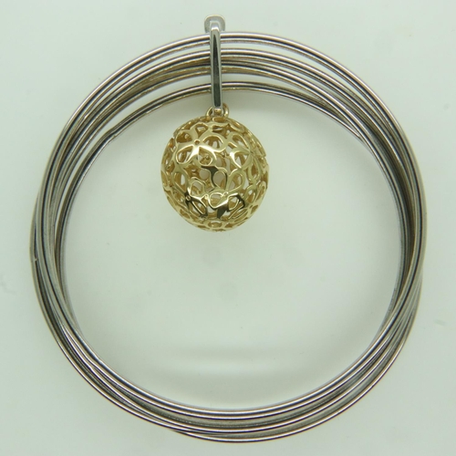 74 - A contemporary Italian silver multi-sectional bangle with silver-gilt pierced ball charm, 25g. UK P&... 