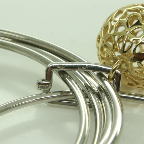 74 - A contemporary Italian silver multi-sectional bangle with silver-gilt pierced ball charm, 25g. UK P&... 