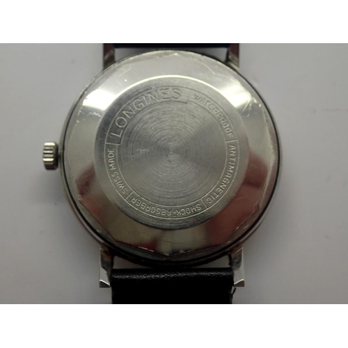 66 - LONGINES: gents automatic wristwatch with silvered dial and date aperture on a black leather strap, ... 