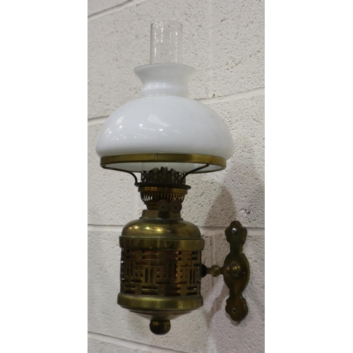 2062 - An early 20th century brass wall mounting oil lamp, with white glass shade and chimney, H: 50 cm. No... 