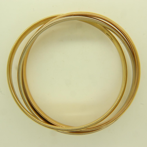 16 - An 18ct tri-gold suite of three interlocking bangles, each D: 70 mm, 46.4g. UK P&P Group 1 (£16+VAT ... 