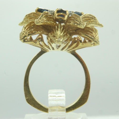 28 - A continental 18ct gold ring, raised floral design set with sapphires and diamonds, comfort shank, s... 