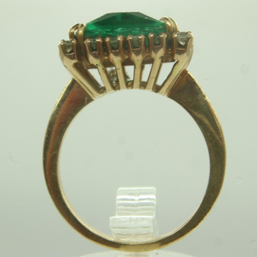 38 - A continental gold cocktail ring, set with a large princess-cut green stone surrounded by twenty dia... 