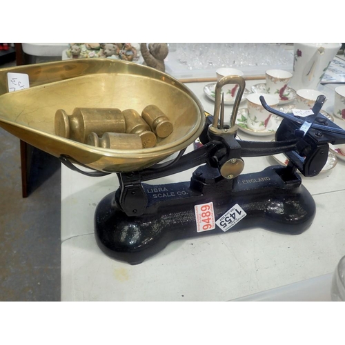 1455 - Pair of Libra black iron scales with two brass pans and four brass weights. Not available for in-hou... 