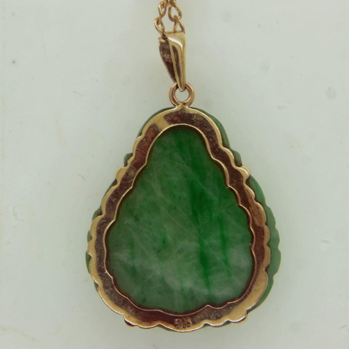 27 - A 9ct gold mounted carved jade pendant in the form of a Buddha, drop L: 25 mm, on a 9ct gold chain, ... 