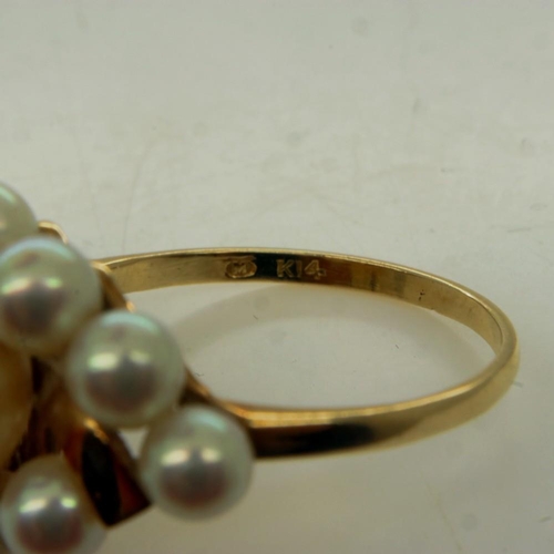 33 - MIKIMOTO: a 14ct gold ring set with a large cultured pearl, surrounded by a further ten smaller pear... 