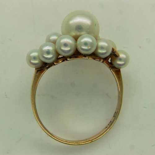 33 - MIKIMOTO: a 14ct gold ring set with a large cultured pearl, surrounded by a further ten smaller pear... 