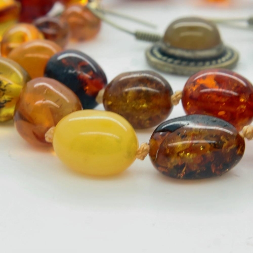 37 - A matched suite of amber jewellery, comprising a beaded necklace of varying ambers including butters... 