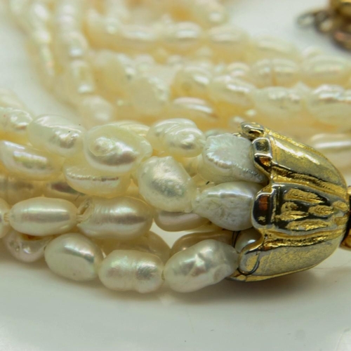 79 - An 8-strand freshwater pearl necklace, on a yellow metal clasp, open L: 50 cm. UK P&P Group 0 (£6+VA... 