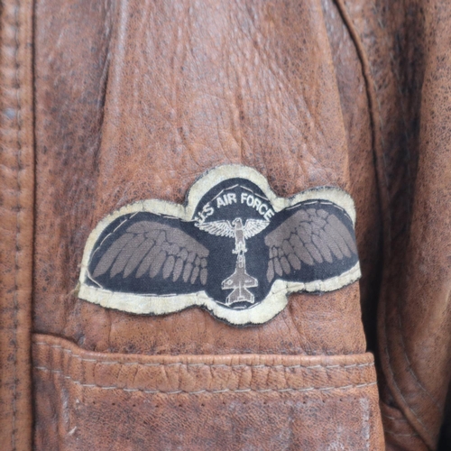 2161 - An American brown leather flying jacket, with sewn patches to the USAF, approximate size M. UK P&P G... 