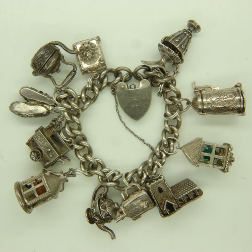 41 - 925 silver charm bracelet with eleven charms, including a teapot example, L: 11 cm, 94g. UK P&P Grou... 