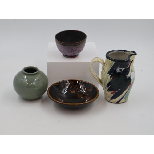 217 - Four pieces of studio pottery to include a jug, vase and two bowls, largest H: 16 cm. Not available ... 