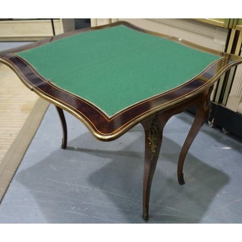 2110 - An early 20th century inlaid kingwood fold-over card table, with serpentine shaped front and ormolu ... 