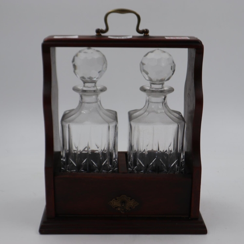 285 - Oak and brass tantalus, containing two crystal decanters, key present. Not available for in-house P&... 