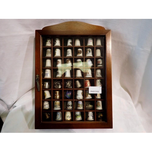 1285 - Forty eight mixed thimbles in a glazed case. Not available for in-house P&P