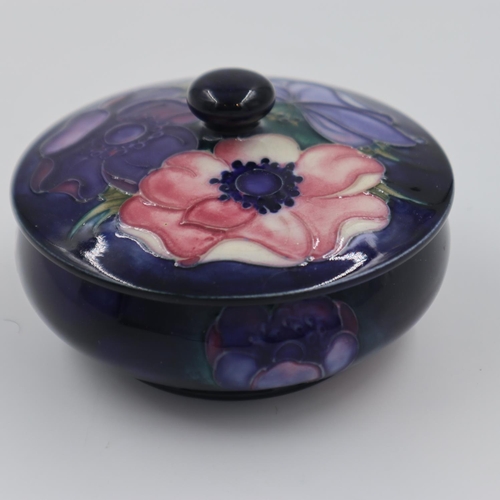 228 - Moorcroft circular lidded powder box in the Anemone pattern, on a blue ground, large section re-glue... 