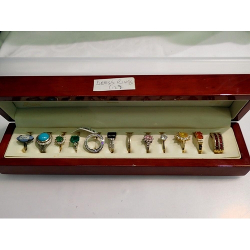 1135 - Wooden case containing 12 stone set dress rings. UK P&P Group 1 (£16+VAT for the first lot and £2+VA... 