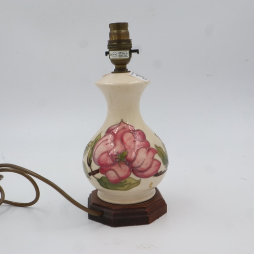 303 - Moorcroft table lamp in the Pink Magnolia pattern on cream ground, raised on a octagonal hardwood ba... 