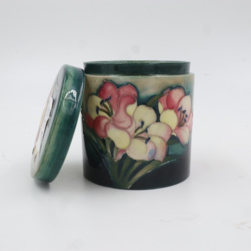 332 - Moorcroft lidded pot in the Freesia pattern, (ill fitting lid), with a lidded box in the Hibiscus pa... 