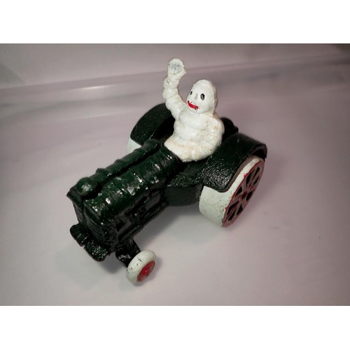 1102 - Cast iron Michelin Man on a tractor, H: 80 mm. UK P&P Group 1 (£16+VAT for the first lot and £2+VAT ... 