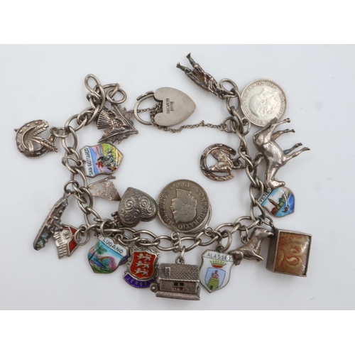 27 - Silver charm bracelet with nineteen charms, including a heart locket and boat, L: 16 cm, 48g. UK P&P... 