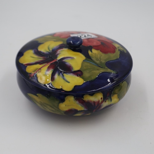 224 - Moorcroft circular lidded box in the Hibiscus pattern, original paper label to base, D: 17 cm. UK P&... 